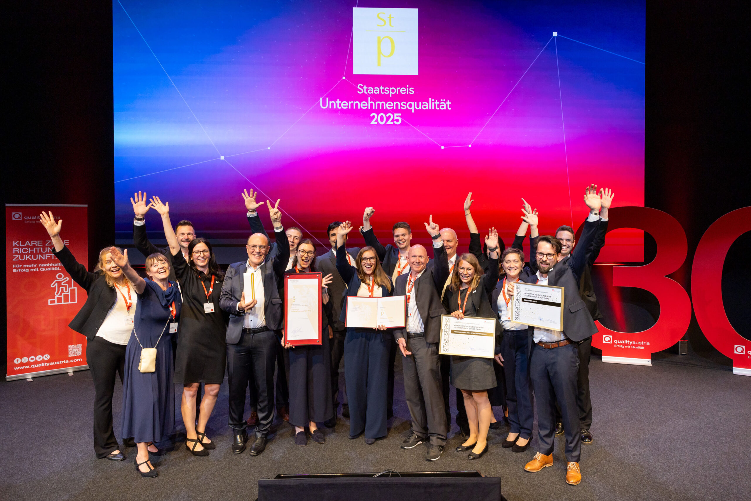 Gewinner des Staatspreises Unternehmensqualität 2025 jubelnd auf der Bühne.